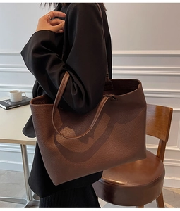 Detail view of deep brown tote bag showing premium lychee grain leather texture and soft finish