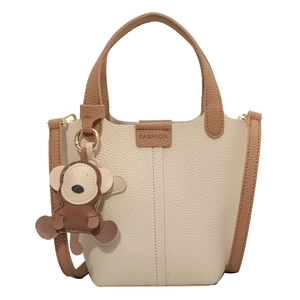 Beige Eimertasche mit braunem Kontrast, Lychee-Struktur und süßem Affenanhänger