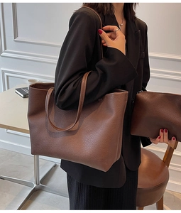 Detail of dark brown lychee leather tote bag with matching pouch shown on a model