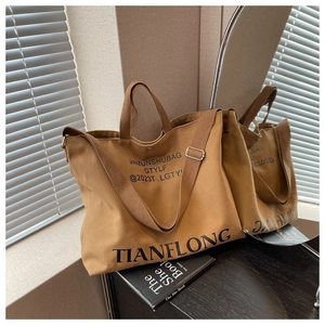 Macro detail of dark brown canvas tote bag featuring adjustable strap and TIANFLONG print