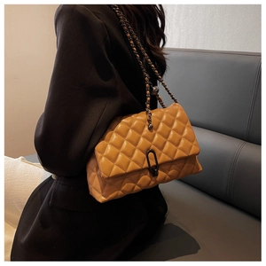 Close-up of brown quilted leather bag featuring a vintage metal clasp and chain strap