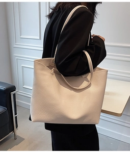 Modern beige litchi grain tote bag styled with a professional black blazer for work