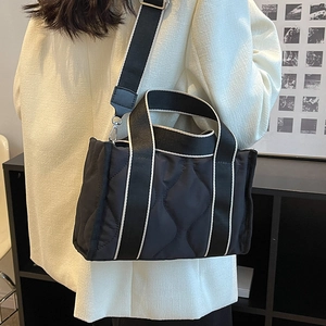 Bolso tote de nailon acolchado negro con asas de tejido en contraste