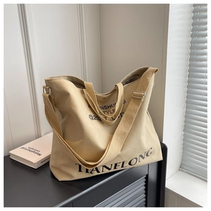 Close-up of khaki canvas tote bag with adjustable strap and HANFLONG print detail