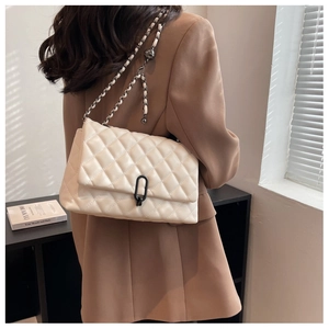 Detail of off-white quilted chain bag showing the elegant metal buckle and PU texture