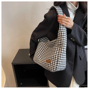Detail of woven houndstooth pattern on high-capacity tote bag with faux leather logo