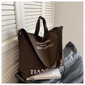 Close-up of large coffee canvas tote bag showing durable texture and white letter printing