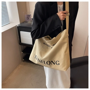 Detailed view of the beige canvas tote bag showing the TIANFLONG logo and fabric texture