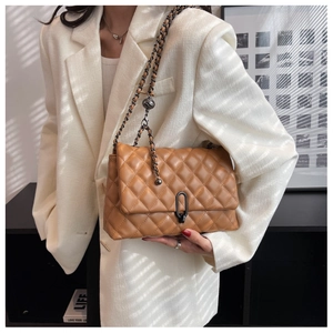 Brown quilted crossbody bag featuring a unique dark metal clasp and chain strap