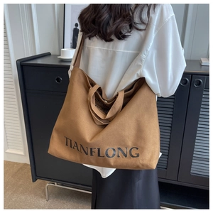 Detail of high-capacity canvas tote bag with TIANFLONG lettering and crossbody strap