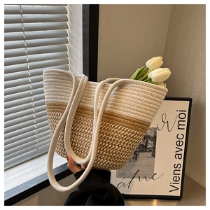 Makrodetail der handgewebten Strohtasche mit beigem Farbverlauf und Webriemen