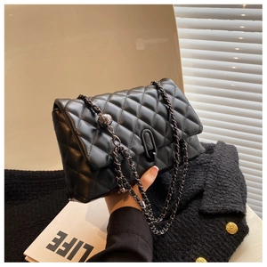 Detail of black quilted leather shoulder bag with metal chain and golden ball adjustment buckle