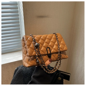 Detailed view of camel quilted leather bag with black metal chain and unique clasp