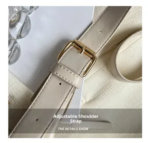 Detail of adjustable cream faux leather shoulder strap with gold metal buckle