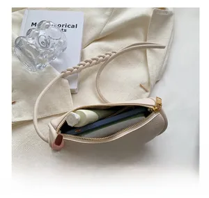 Macro shot showing internal capacity of ivory leather bag with phone and lipstick