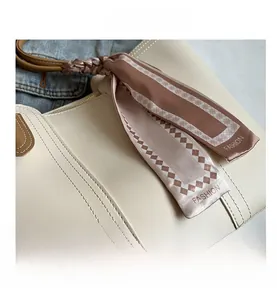 Detail of cream leather tote with decorative silk scarf and stitching accents