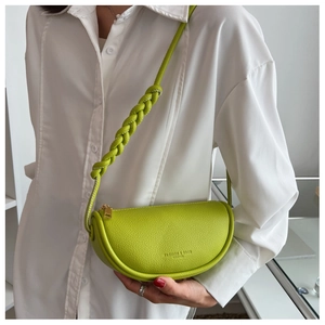 Detail of lime green half-moon saddle bag with braided strap and lychee texture
