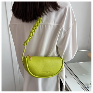 Close-up of fluorescent yellow saddle bag with lychee texture and braided shoulder strap