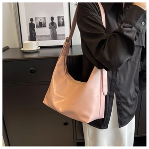 Close-up of pink leather hobo bag with adjustable strap and sleek crescent moon design