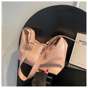 Close-up of pink faux leather bag with lychee texture and gold metal buckle