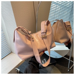 Macro detail of pink leather dumpling bag with wide strap and golden adjustment buckle