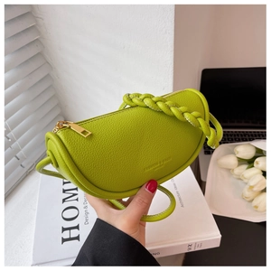Detail of a bright green lychee leather crescent bag with a unique woven handle design
