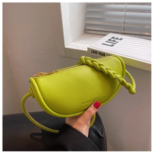 Detail of lime green half-moon bag featuring woven handle and lychee leather texture