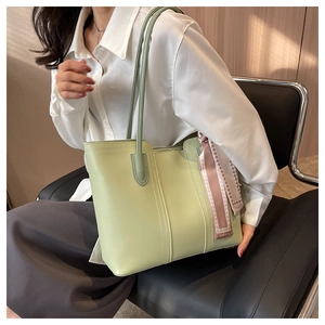 Detail of mint green tote bag featuring a decorative fashion scarf and neat stitching