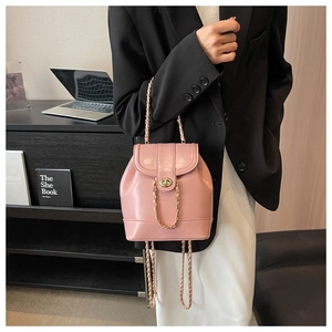 Détail du sac seau rose en cuir avec chaîne et fermoir pivotant doré pour femme