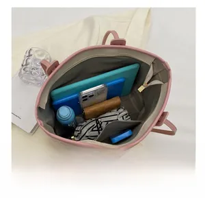 Top view of spacious pink tote bag interior showing laptop, water bottle and umbrella