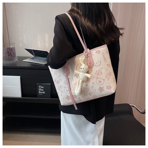Detail of graffiti tote bag with pink straps and a cute bunny plush charm