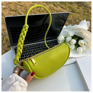 Detail of lime green cylinder saddle bag with litchi texture and woven handle