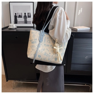 Close-up of large graffiti tote bag with plush rabbit charm and blue handles