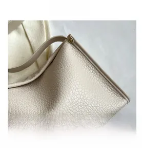 Dettaglio della pelle martellame litchi crema con borchie metalliche sulla borsa tote