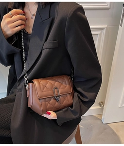 Détail du sac bandoulière matelassé marron foncé avec chaîne en métal et boucle
