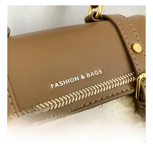 Dettaglio della borsa in pelle marrone con finiture dorate e motivi eleganti in rilievo