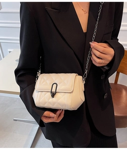 Détail du sac matelassé avec bandoulière chaîne argentée et boucle noire décorative