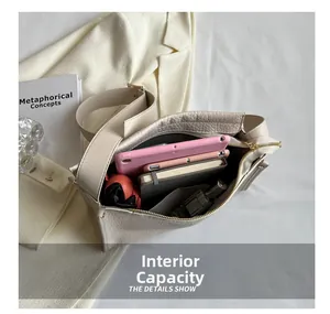 Interno della borsa a tracolla color crema che mostra la capienza per tablet e oggetti vari
