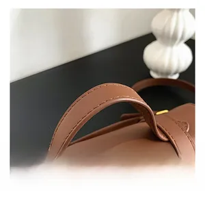 Dettaglio del manico in pelle cucito con cura su una borsa a tracolla marrone