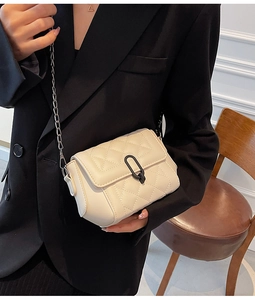 Détail du petit sac bandoulière beige matelassé avec chaîne argentée et fermoir métal