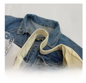 Detail showing the comfortable wide canvas shoulder strap and natural fabric texture