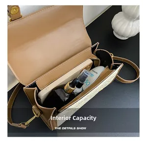 Primo piano dell'interno capiente della borsa a tracolla kaki con oggetti essenziali
