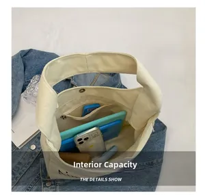 Detail view of the spacious inner compartment and zipper pocket of the canvas tote bag