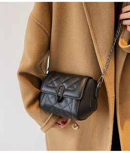 Détail du sac à bandoulière noir matelassé avec fermoir en U et bandoulière chaîne