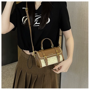 Dettaglio di una borsa a tracolla vintage in pelle con monogramma marrone e fibbia in metallo