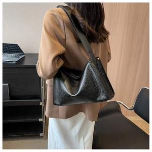 Dettaglio della borsa hobo in pelle nera testurizzata con hardware dorato e tracolla