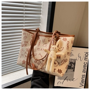 Detail showing graffiti prints and fluffy rabbit pendant on large tote bag