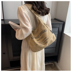 Khaki canvas tote bag with black typography shown in a minimalist interior setting