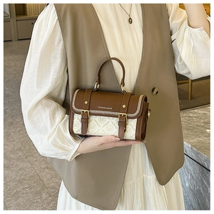 Dettaglio della borsa in pelle bicolore marrone e beige con finiture dorate e motivo monogram