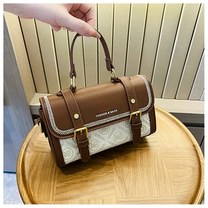 Dettaglio ravvicinato di una mini borsa vintage marrone e beige con finiture dorate